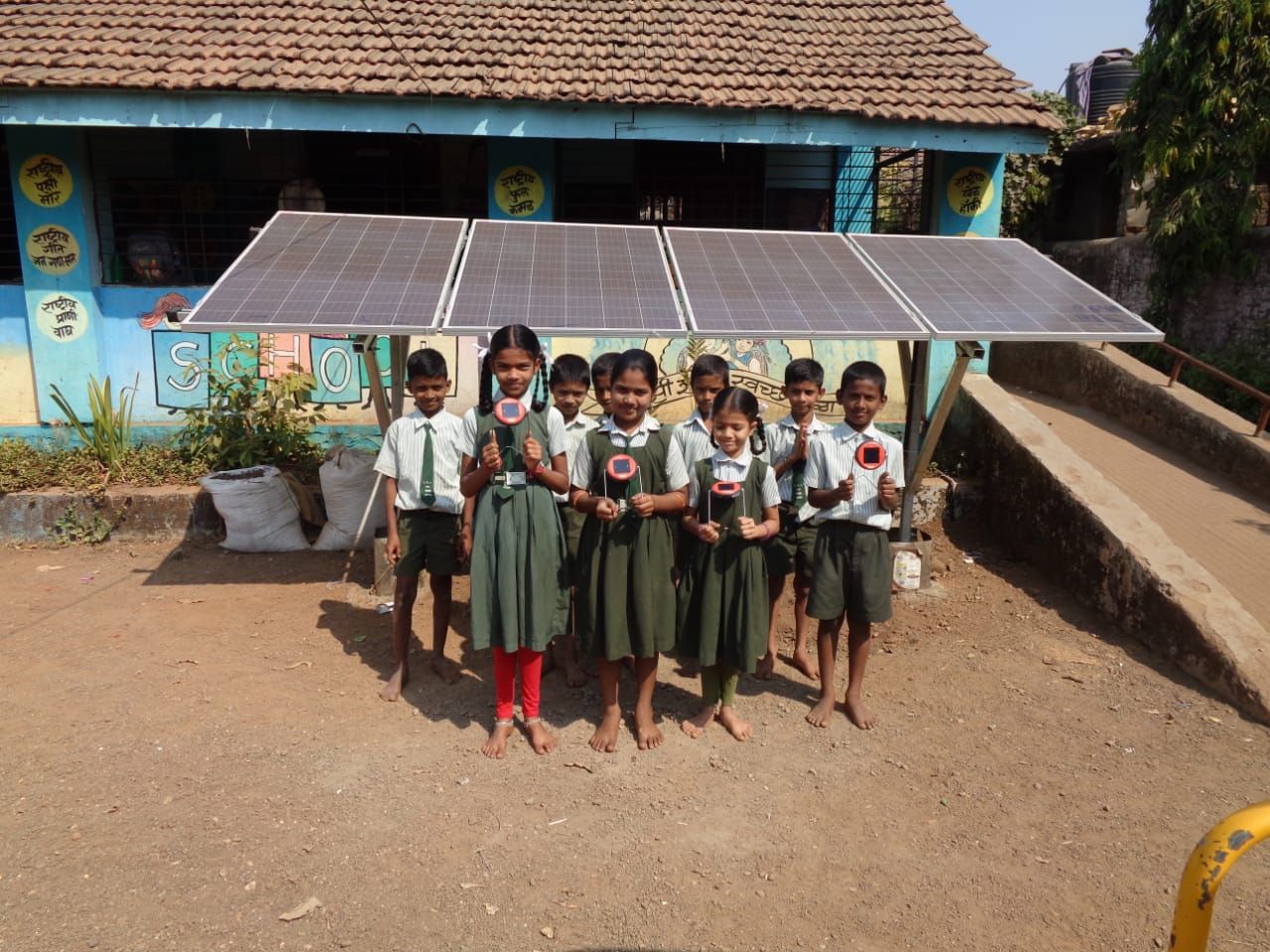 Students at a rural Indian school standing in front of their new solar array